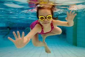 smiling girl swimming underwater