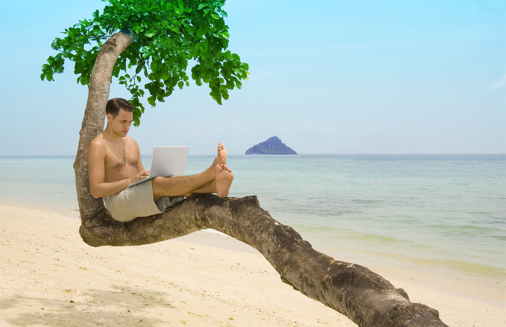 man with laptop on beach
