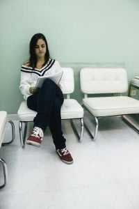 Patient reading sitting in the waiting room of a clinic