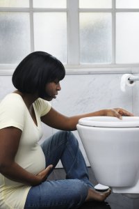Pregnant woman by toilet feeling sick
