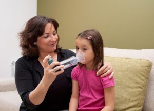 teacher using inhaler with child