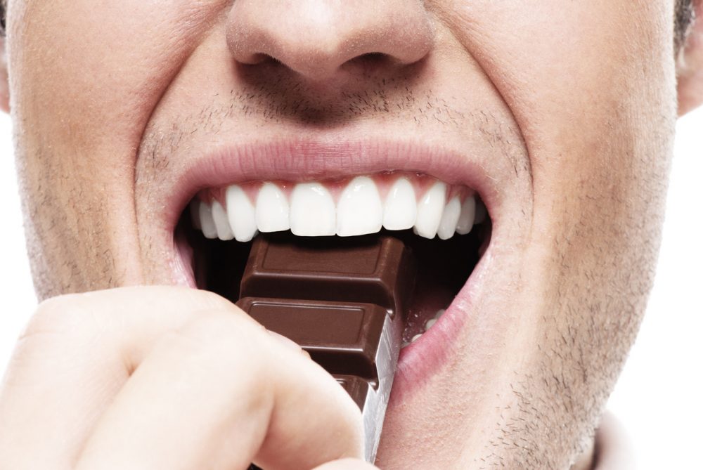 mouth of man eating chocolate