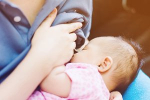 Baby feeds on  mother's breasts milk