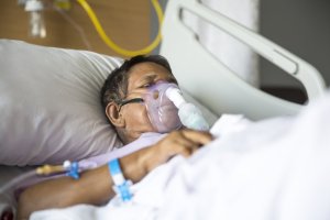 elderly patient in hospital bed receiving ventilation - a bed to prevent or treat pressure ulcers